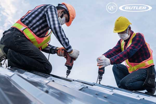 two men with drills installing a metal roofing sytem